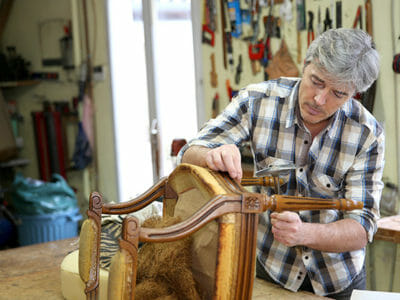 A man upholstering a chair