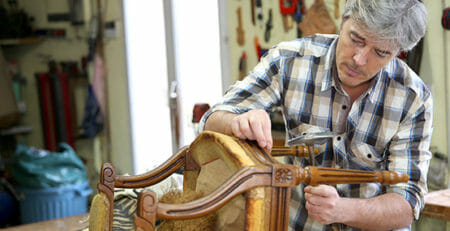 A man upholstering a chair